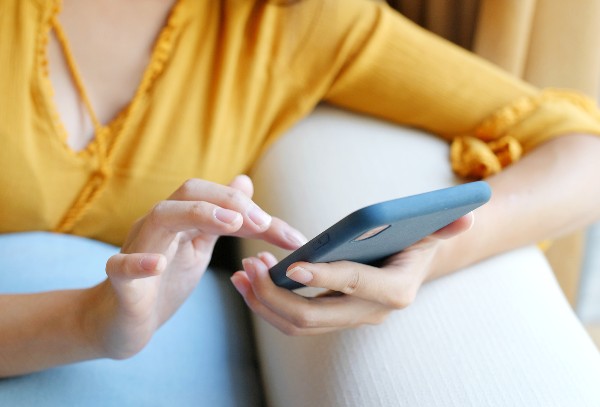 woman in yellow shirt holding phone