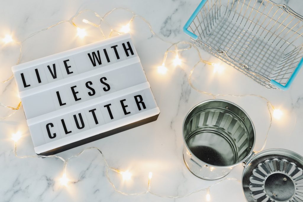 live with less clutter sign, decluttering tips