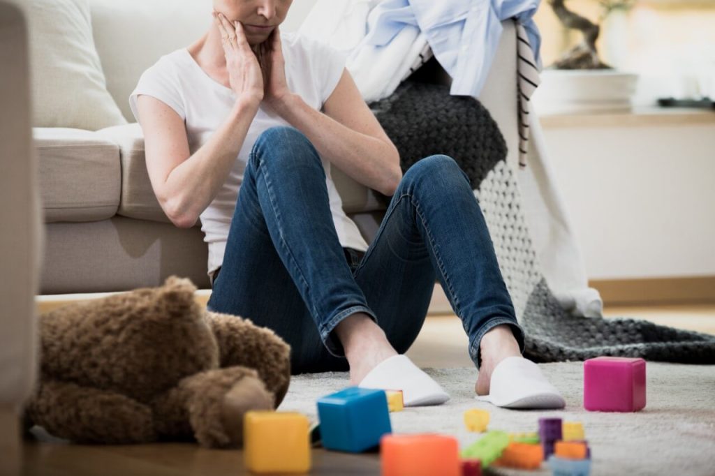 overwhelmed mother in messy living room