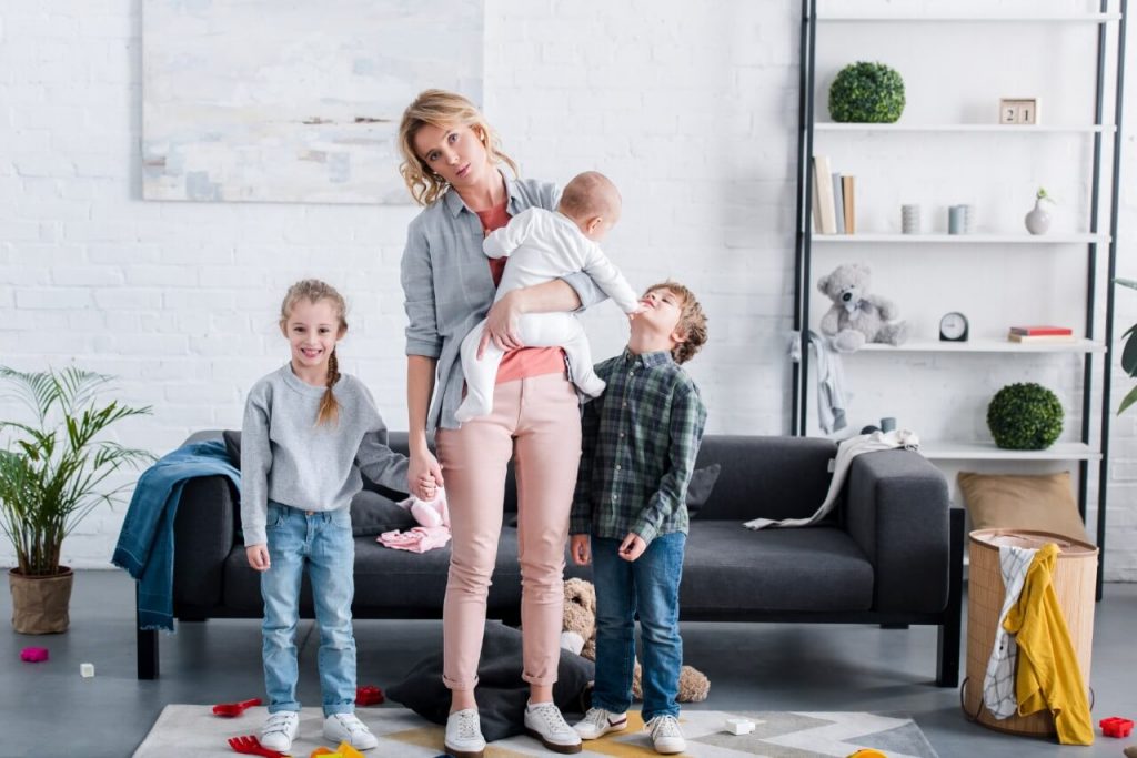 overwhelmed mother with kids in messy house