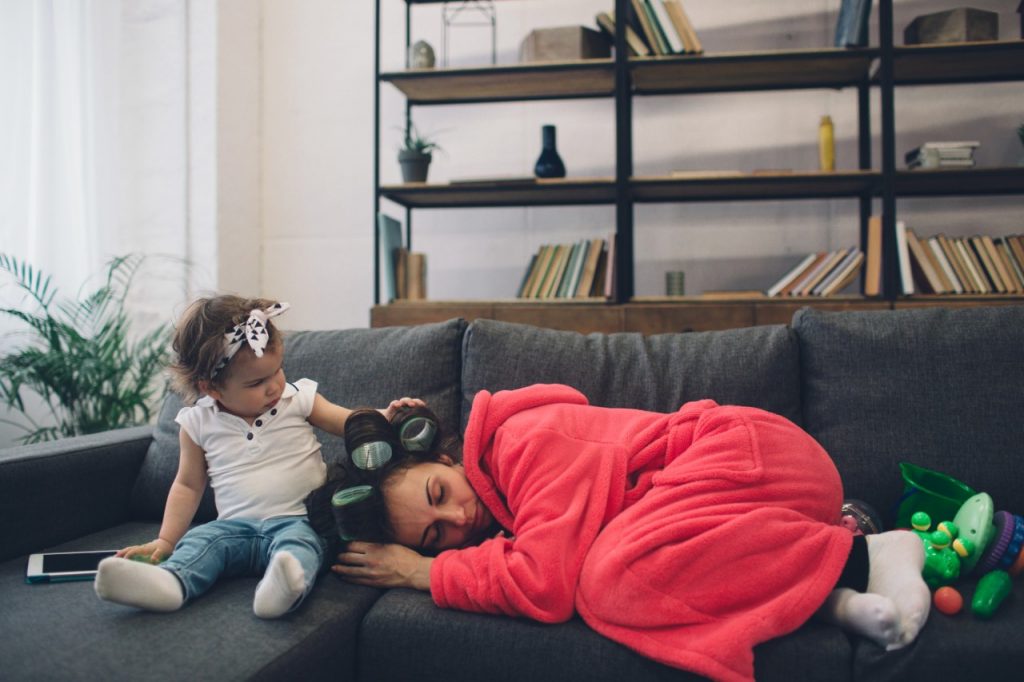 depressed mother on couch in bathrobe