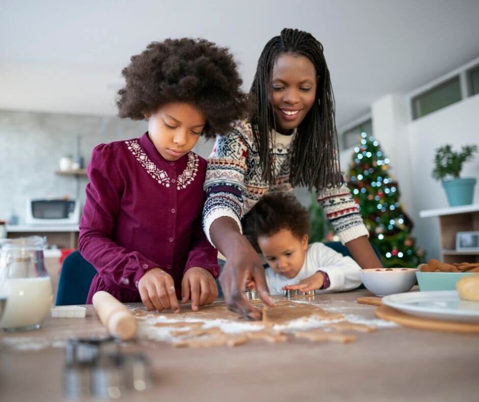 happy black mother and children making christmas cookies together