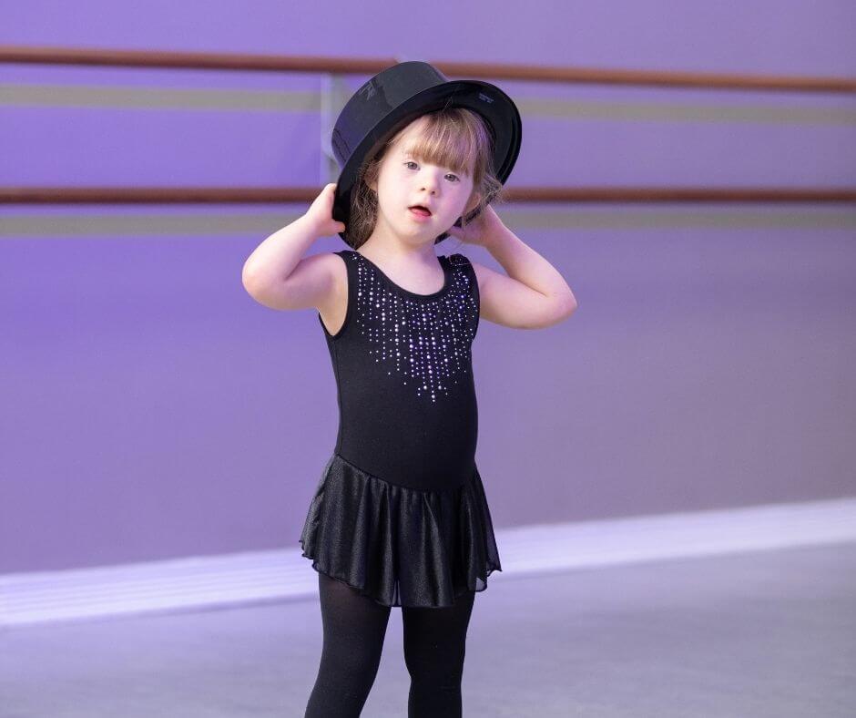 young girl with Downs Syndrome in a jazz dance costume at her dance class