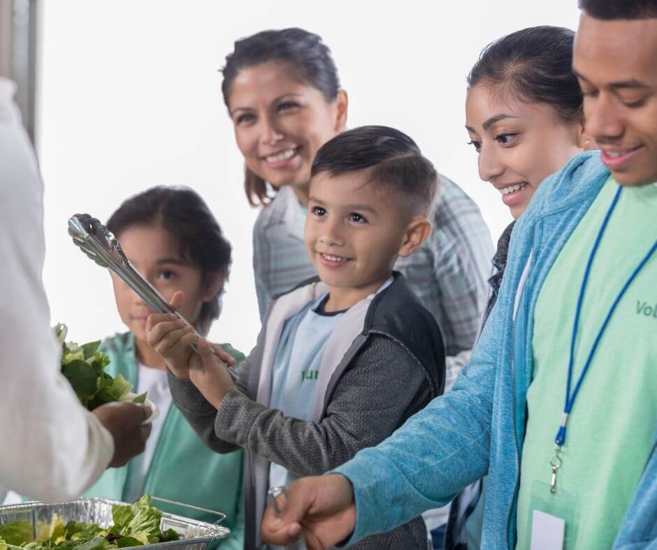 family serving together at a food kitchen