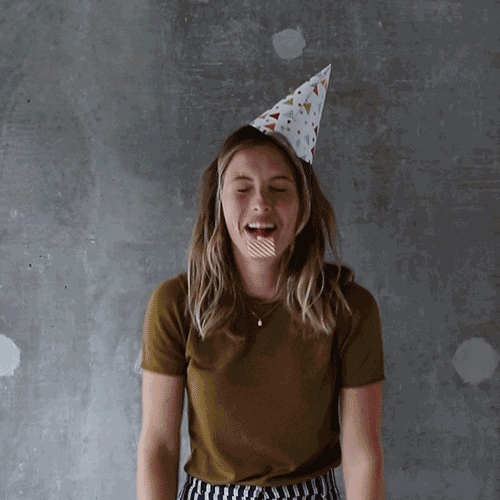 celebrating woman with party hat and confetti