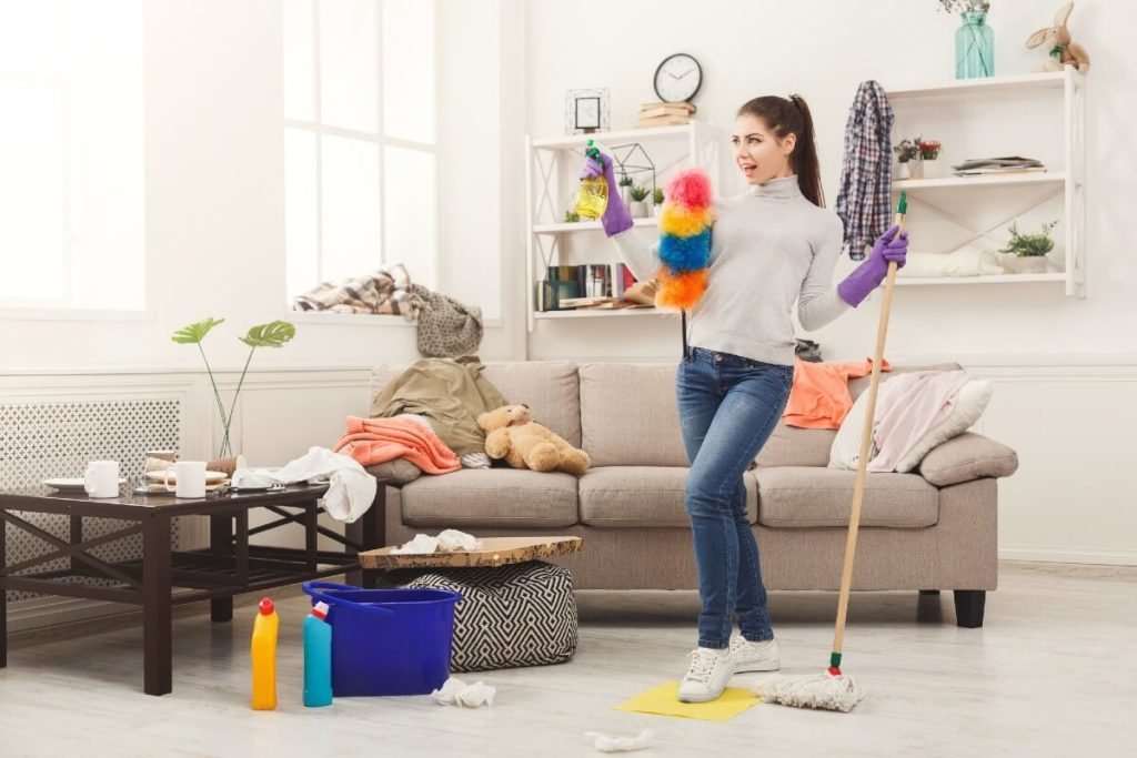 happy woman cleaning living room