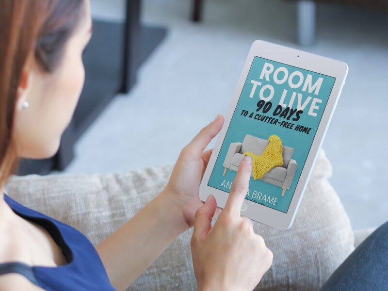 Woman reading step-by-step decluttering book ebook Room to Live on iPad mini