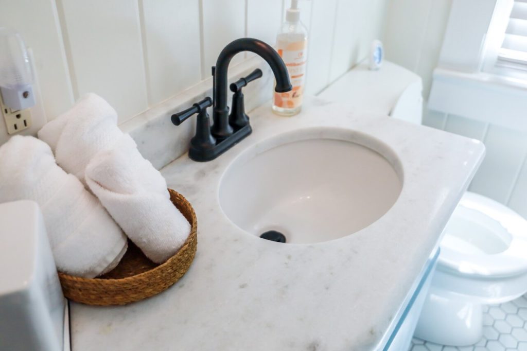 small bathroom with towels in basket on counter of sink