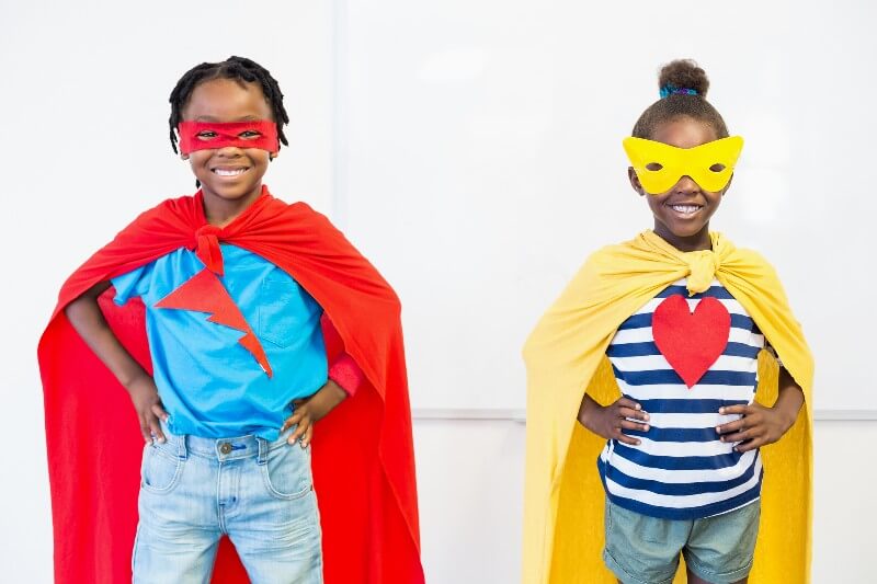 Kids wearing superhero capes and masks.