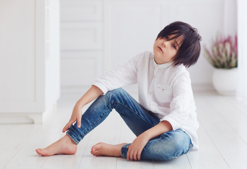 annoyed looking child sitting on floor