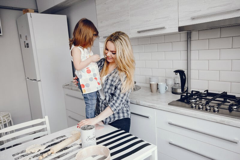 Mother and daughter baking in a kitchen.
