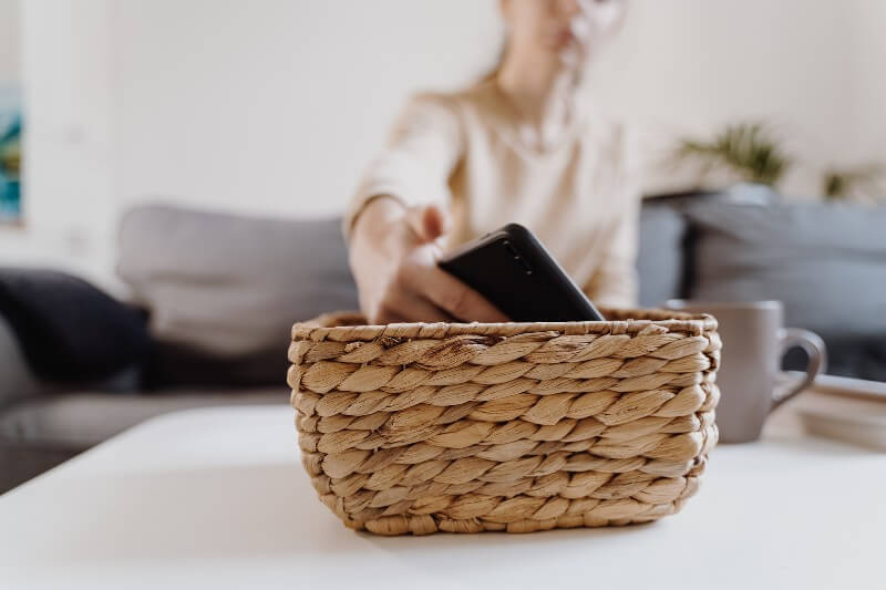 Woman putting phone in a basket.